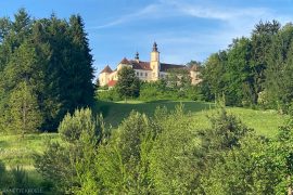 Schönes Schloss am Hügel, aw man im Tal Golf spielen kann.