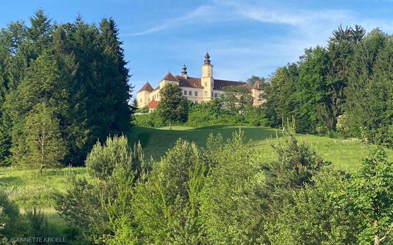 Schönes Schloss am Hügel, aw man im Tal Golf spielen kann.